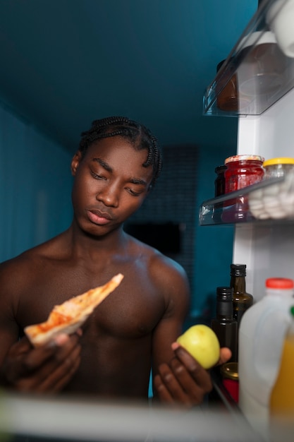 Person opening refrigerator late at night in dark kitchen